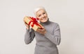 Excited senior woman shaking present box trying guess what inside Royalty Free Stock Photo