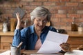 Excited senior woman reading fantastic news in postal letter
