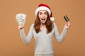 Excited shocked caucasian lady holding money and credit card