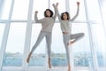 Excited sisters in casual jumping high together Royalty Free Stock Photo