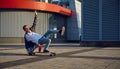 Excited skilled hipster guy making stunt on skateboard riding fast Royalty Free Stock Photo