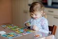 Excited smiling cute toddler girl playing picture card game. Happy healthy child training memory, thinking. Creative Royalty Free Stock Photo