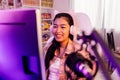 Excited and smiling gamer girl in cute headset with mic playing an online video game. Young Asian woman talking to Royalty Free Stock Photo