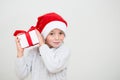 Excited smiling little boy in red santa hat with gift box isolated on white background, banner copy space. Christmas Royalty Free Stock Photo