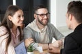 Excited smiling millennial couple discussing mortgage loan inves