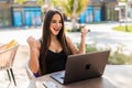 Excited smiling woman celebrating online win, using laptop in cafe, looking at screen, screaming with raising hands, receiving Royalty Free Stock Photo