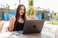 Excited smiling woman celebrating online win, using laptop in cafe, looking at screen, screaming with raising hands, receiving Royalty Free Stock Photo