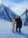 Excited snowboarder poses with her snowboard before riding down the mountain.