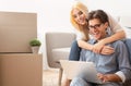 Excited Spouses Relaxing With Laptop Computer After Moving Apartment