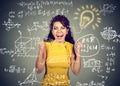 Excited student with idea light bulb and maths and science formulas on blackboard Royalty Free Stock Photo