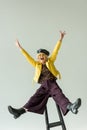 excited stylish senior woman in yellow jacket and leather beret,