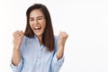 Excited successful ambitious middle-aged brunette woman in office blue blouse winning bet, fist pump celebration gesture