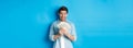 Excited successful man counting money, looking satisfied at cash and smiling, standing over blue background Royalty Free Stock Photo