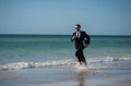 Excited summer business travel. Freelance work, online working. Summer businessman in suit run in sea water. Freelance Royalty Free Stock Photo