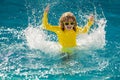 Excited summer. Child splashing in summer water pool. Kid splash in pool. Excited happy little boy jumping in pool Royalty Free Stock Photo
