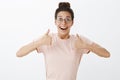 Excited supportive and happy charismatic female friend cheering mates during competition raising thumbs up and smiling