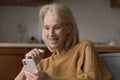 Excited surprised senior smartphone user woman reading text message