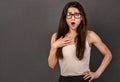 Excited surprising confused funny business woman with open mouth in glasses in white shirt holding the hand on the chest on empty Royalty Free Stock Photo