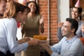 Excited team congratulate colleague in office making birthday present