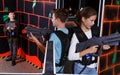 Excited teen boy and girl aiming laser gun at other players Royalty Free Stock Photo