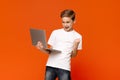 Excited teen boy using laptop computer, celebrating success