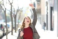 Excited teen celebrating good news in the street