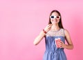 Excited female teenager girl wearing 3D glasses eating popcorn isolated on pink background Royalty Free Stock Photo