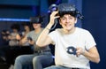 Excited teenager having fun with friends in virtual reality room