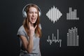 Excited teenager showing a rock sign while listening to music in headphones Royalty Free Stock Photo