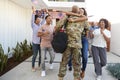 Excited three generation African American family welcoming millennial soldier returning home,back view