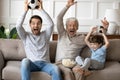 Excited three generations of men watching football together