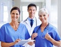 Excited to be on call. Portrait of a smiling medical team standing in a hospital corridor. Royalty Free Stock Photo