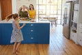 Excited to try the popular family recipe. a little girl dancing while her mother and grandmother cooks in the background