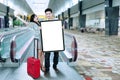 Excited tourists holding billboard