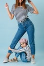 Excited tween girl holding her mom& x27;s leg, mom is in a girly playful pose Royalty Free Stock Photo