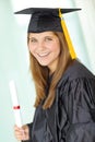 Excited about what the future holds. A pretty college student in her graduation gown holding her degree and smiling Royalty Free Stock Photo