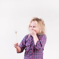 Excited wide eyed female child wearing plaid shirt yelling with flaming match Royalty Free Stock Photo