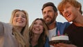 Excited woman celebrating birthday with cheerful friends outdoors close up. Royalty Free Stock Photo