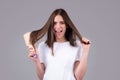 Excited woman combs her healthy hair. Combing healthy long straight female hair, close up.