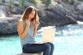 Excited woman finding online offer on the beach