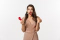 Excited woman holding engagement ring and red box, looking surprised and amazed, receive marriage proposal on date Royalty Free Stock Photo