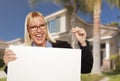 Excited Woman Holding House Keys and Blank Real Estate Sign Royalty Free Stock Photo