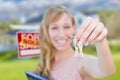 Excited Woman Holding House Keys and Sold Real Estate Sign in Fr Royalty Free Stock Photo