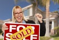 Excited Woman Holding House Keys and Sold Real Estate Sign Royalty Free Stock Photo