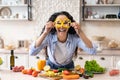 Excited woman making glasses of sweet pepper, having fun and playing with food while cooking fresh salad Royalty Free Stock Photo