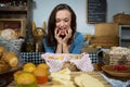 Excited woman purchasing sweet food at bakery counter