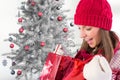 Excited woman in red beanie cap checking her christmas gifts Royalty Free Stock Photo