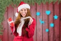 Excited woman in santa costume opening christmas gift