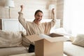 Excited woman unboxing parcel, looking into open cardboard box Royalty Free Stock Photo