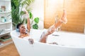 Excited woman wearing headphones happy dancing in foam bath in a sunny morning routine. Happiness. Royalty Free Stock Photo